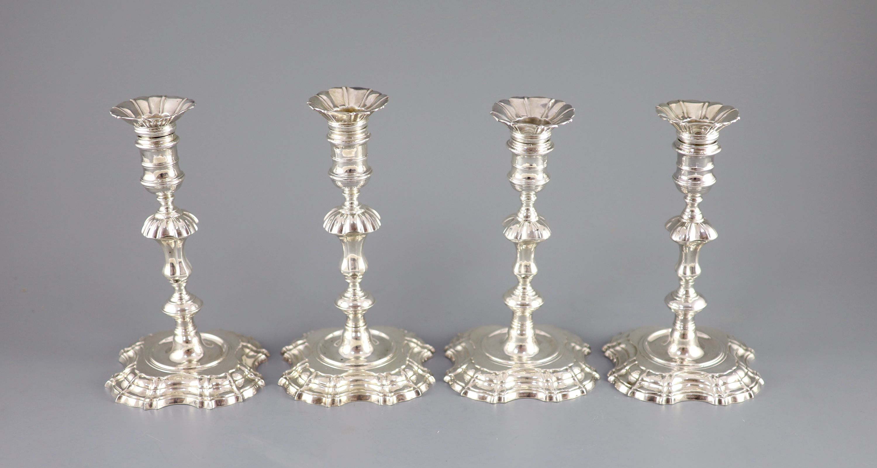 A near set of four George II cast silver candlesticks, by John Cafe